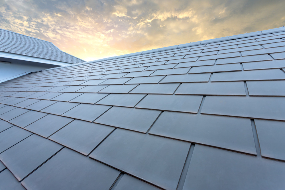 Slate,roof,against,blue,sky,,gray,tile,roof,of,construction